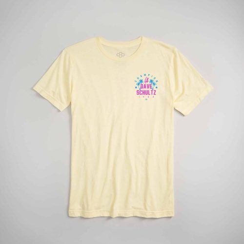 A light yellow t-shirt featuring colorful graphic text and palm tree designs celebrating Dave Schultz an iconic figure from 1984