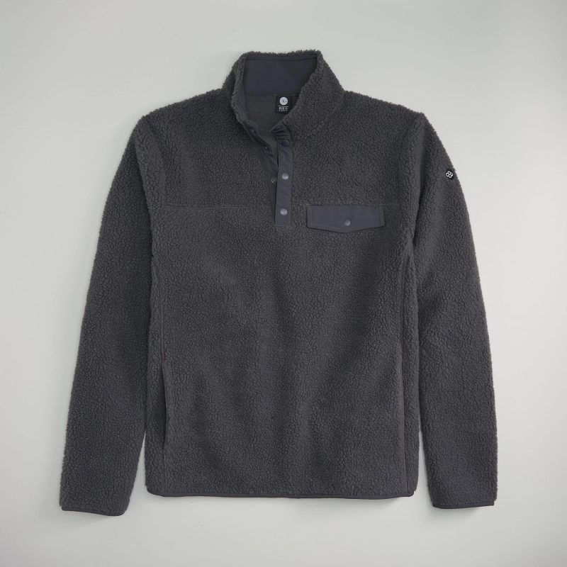 This image displays a cozy black pullover made from soft fleece material featuring a quarter-length zipper and a chest pocket with a button closure