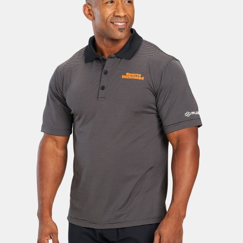 A smiling man is wearing a black and gray striped polo shirt with the text Sports Illustrated and a logo on the sleeves standing against a plain background