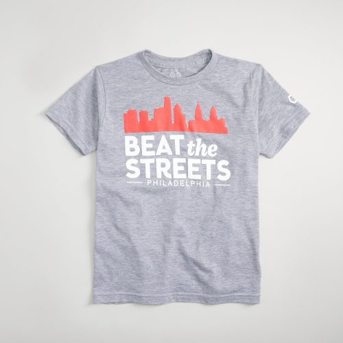 A gray t-shirt featuring a graphic design that includes the text BEAT the STREETS along with a silhouette of city buildings and the word PHILADELPHIA