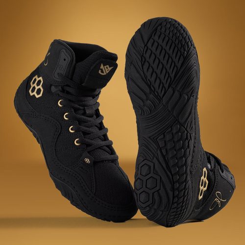 A stylish pair of black high-top sneakers with gold accents positioned on a warm golden background to highlight their sleek design